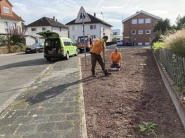 Straßenarbeiter reparieren den Gehweg mit Spezialwerkzeugen.